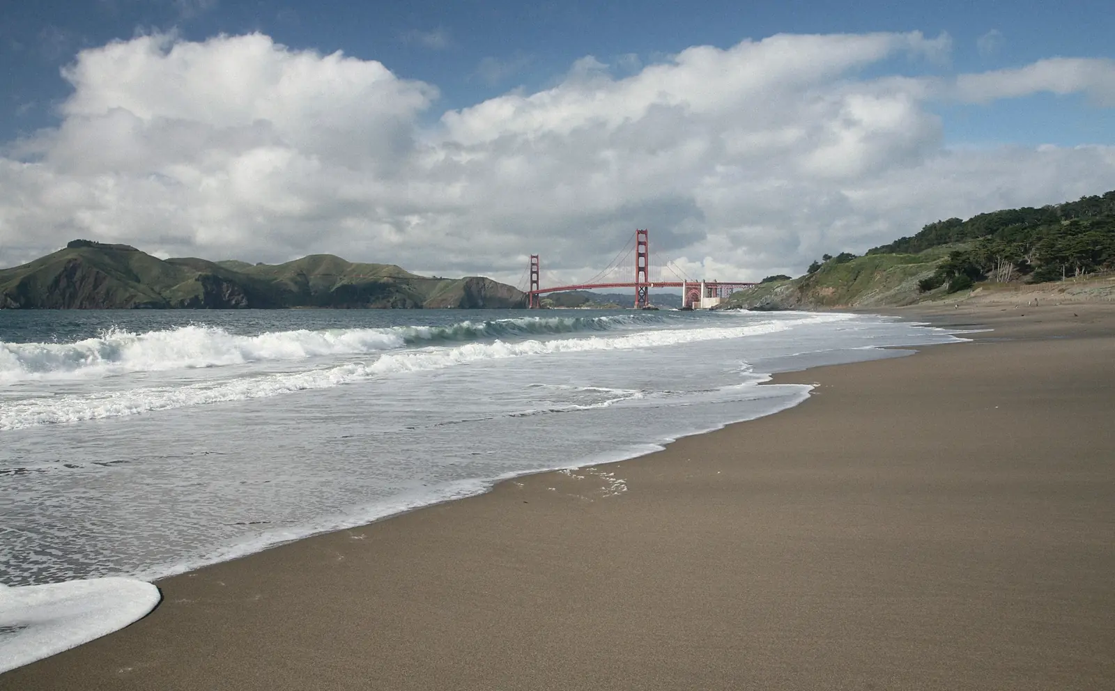 Photo of waves at Baker Beach with the Golden Gate Bridge in the distance